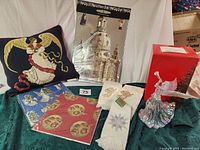 Full lot arranged showing tapestry pillow with angel, advent calendar image, embroidered towels, gift wraps, acrylic angel tree topper in original box