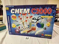 Front of original Chem C2000 box showing the experiment kit contents including test tubes, beakers, pipettes, and safety goggles, highlighting 250 experiments for ages 11+.