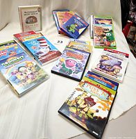Photo showing an assortment of children's DVDs including Guess How Much I Love You, The Cat in the Hat, Puss in Boots, Barney, and VeggieTales DVDs.