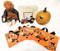 Photo showing all items in the lot: scarecrow doll seated, Williraye Studio Racing Witch figurine in original box, carved pumpkin, and six Happy Halloween orange treat bags.