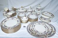 Full set of plates, cups and serving pieces arranged on white backdrop