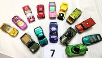 Top-down view of all 14 metal Matchbox cars arranged in a semicircle showing variety and condition.