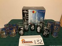 Photo showing entire lot on table with original Luminarc box, group of decorated glasses including Luminarc Ashley set and Arby's Collector Series glasses
