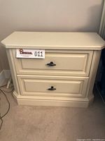Ivory cream armoire nightstand front view showing two drawers with metal handles.