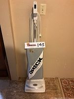 Full front view of Oreck XL2 vacuum, showing fabric bag with logos and power cord wound on handle.