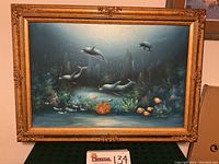 Full view of the framed "Under The Sea" painting showing the underwater scene with dolphins and tropical fish, signature visible.