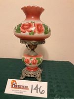 Front view of vintage rose parlor lamp showing hand-painted pink and red roses on milk glass, scalloped lamp shade, and decorative metal base.