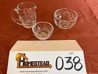 Set of three pieces on a red patterned tablecloth with an estate sale lot card.