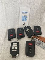 Six automotive key fobs (five Toyota and one Honda) displayed on a white towel