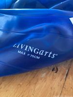 Close up photo of the deflated blue Livingarts exercise ball showing brand name and size label.