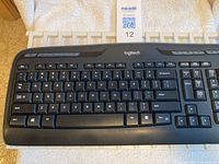 Top-down view of Logitech keyboard showing QWERTY keys, multimedia shortcut keys, and numeric keypad.