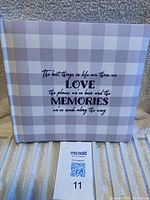 View of the front cover showing the gray and white checked pattern and inspirational quote printed in black.