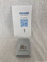 Closed view of the silver Zippo lighter with Bathurst logo on the front, showing its compact rectangular design.