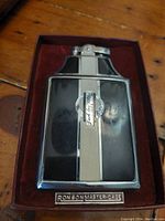 Vintage Ronson Master-Case lighter in black and silver with Jack Love Violet branding, set in maroon velvet holder.