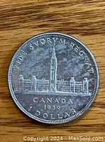 Reverse side of 1939 Canadian silver dollar depicting Parliament buildings with inscriptions and date.