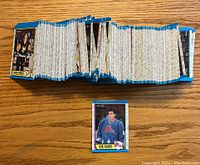 Stack of 1989-90 O-Pee-Chee hockey cards arranged side by side showing card backs and edges, single Joe Sakic rookie card displayed separately at the front.