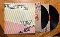 Front cover of Aerosmith Live! Bootleg double vinyl album with vinyl records partially removed from sleeve.