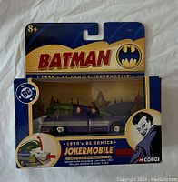 Front view of the sealed Corgi 1950's DC Comics Jokermobile die-cast car in packaging showing Batman logo and Joker image on box.