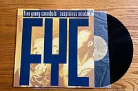 Front cover of Fine Young Cannibals Suspicious Minds vinyl record album with large blue letters and photo of band members.