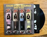 Front of Grand Funk Railroad Born to Die vinyl album cover with record partially visible behind it.