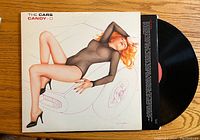Front album cover of The Cars 'Candy-O' vinyl showing stylized image of a woman reclining over a car hood.