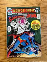 Front cover of World's Finest Comics #202 showing Superman and Batman with a cloaked figure on a wooden surface.