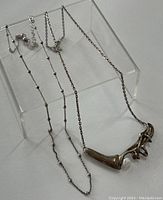 Two vintage sterling silver necklaces shown laid out to display chain and pendant detail
