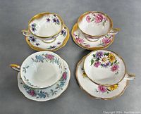 Overview of all four Royal Standard teacups each with matching saucer showing varied floral designs and gold trim
