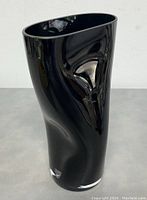 Side view of black glass vase showing asymmetrical design and original Orrefors sticker near base.