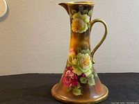 Front view of the antique Nippon porcelain pitcher showing floral decoration and shape.