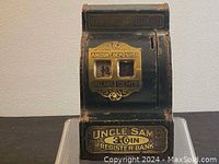 Front view of antique Uncle Sam 3 Coin Register Bank showing 'Amount Deposited' window and coin slots.