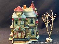 Front and partial side view of the green Christmas Valley ceramic house with detailed windows, red roof, and holiday motifs.