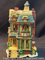 Front view of ceramic dentist building showing detailed facade, windows, stairs, and dental sign.