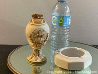 Porcelain lighter and ashtray set placed on a round mirror, water bottle for size reference