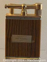 Front view showing wood paneling, metal plaque engraved with "Compliments of Bud Russell 1971," and lighter mechanism on top.