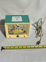 Front view of 1950s Hankscraft Snow White TV light with original power cord and measuring tape showing size.