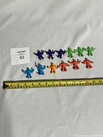 Full lot of 10 vintage M.U.S.C.L.E. Men toy figures in six colors arranged in two rows, with a measuring tape indicating about 2 inches tall each figure.