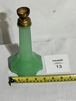 Full view of the green jadeite glass lamp base with brass fitting, showing shape and proportions next to measuring tape.