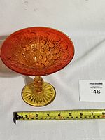 Side view of amberina pedestal bowl with measuring tape showing approximate size.
