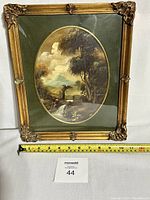 Front view of the framed oval oil painting showing subject and frame details with tape measure for scale