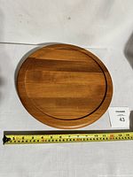 Top view of round teak Lazy Susan showing natural wood grain and smooth finish with measuring tape indicating approximately 14 inches diameter.