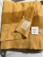 Photo of the folded Hudson Bay wool blanket showing the harvest gold colors and sewn label.