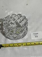 Clear large round decorative bowl made of cut crystal with diamond pattern and scalloped rim.