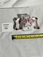 Porcelain ashtray with floral designs and measuring tape showing size.