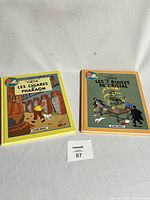 Two hardcover Tintin comic books, front covers shown, colorful cartoon illustrations, square format, titled in French