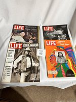 Top view of four LIFE magazines laid out on a white surface showing front covers with various imagery and text from the 1970s.