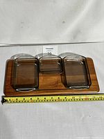 Full view of teak rectangular serving tray with three glass dishes, two present, one missing. Tape measure shows approx 31 cm length.