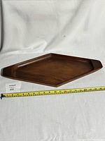 Diamond-shaped teak wood tray laying flat with measuring tape showing length around 21 inches.