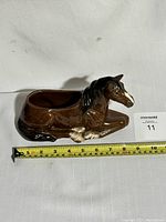 Clear side view of ceramic horse planter measuring about 12 inches long.