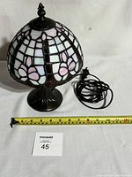 Full view of Tiffany style stained glass desk lamp with cord and measuring tape showing size.